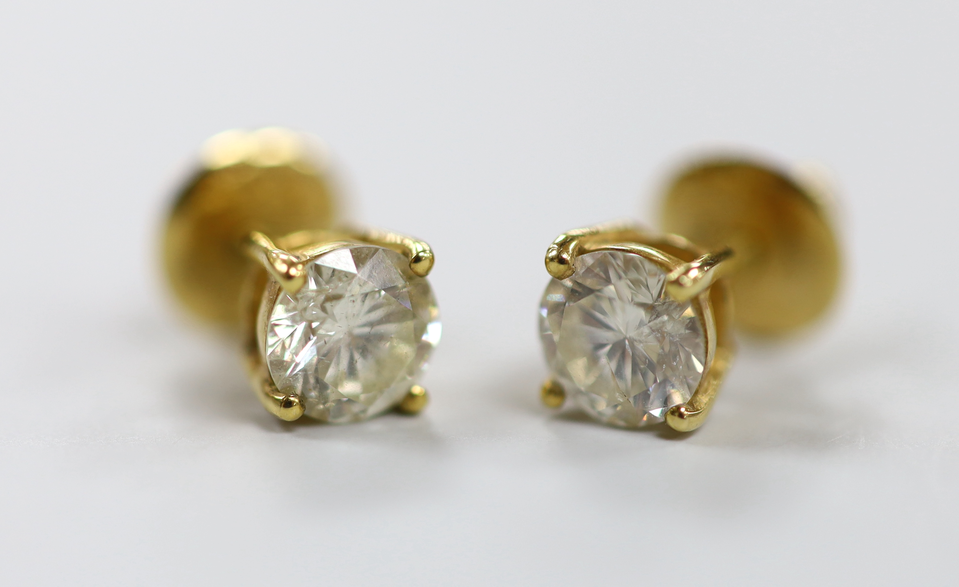 A pair of yellow metal and solitaire diamond set ear studs, gross weight 2.9 grams